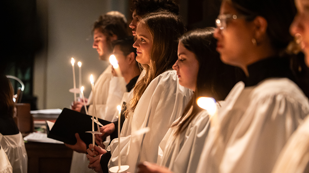 A line of students holding candles
